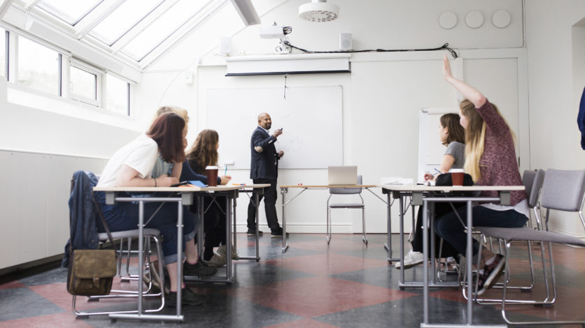 Diskussionsfrågor för individanpassad vuxenutbildning, på bilden sitter elever och tittar på läraren vid en whiteboard