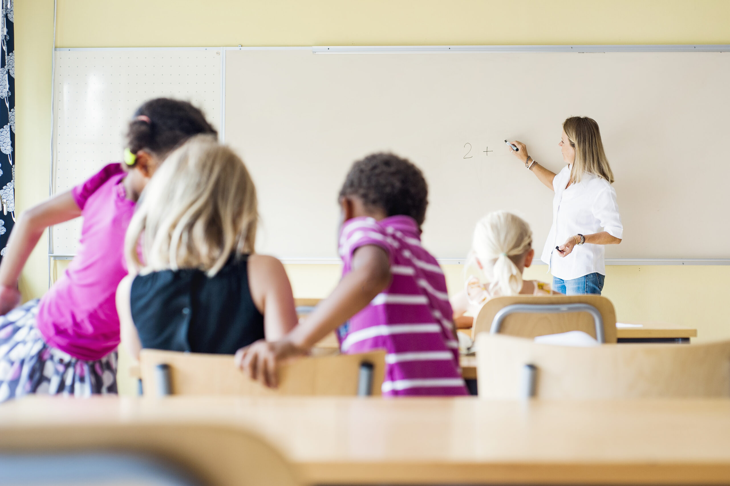 Barn tillsammans med lärare i ett klassrum tränar tal.